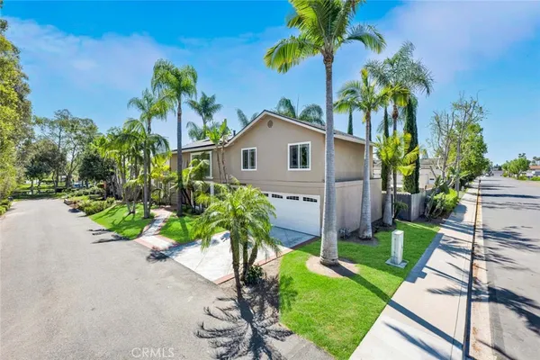a front view of a house with a yard and potted plants