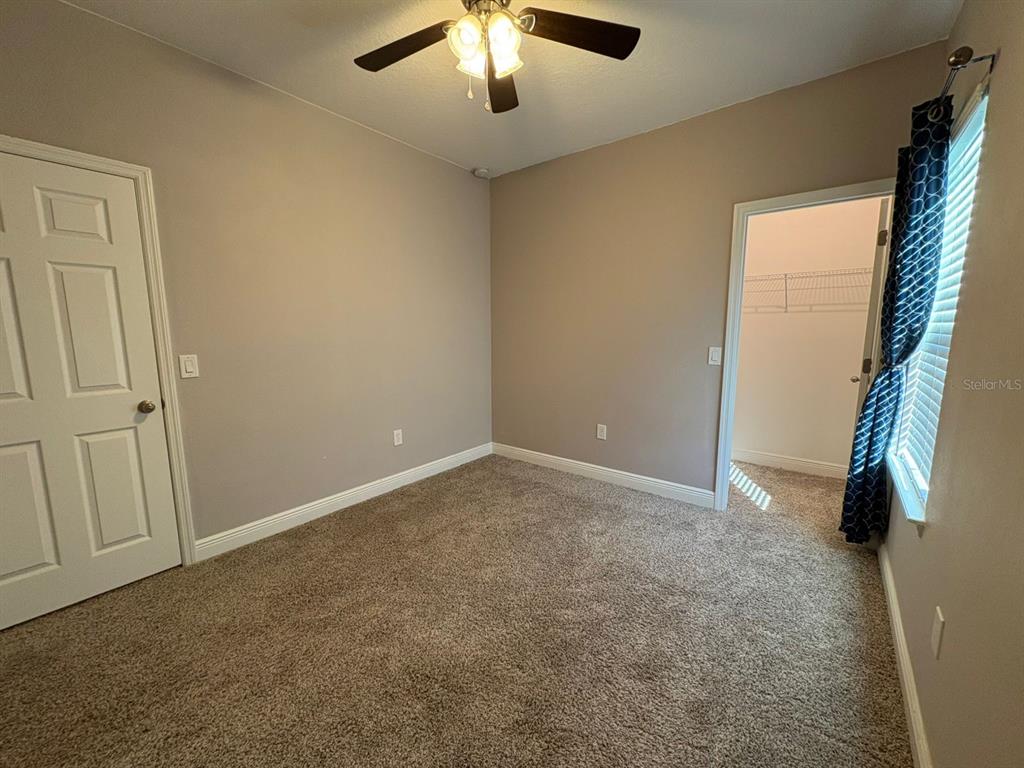 9640 Amber Chestnut Way Winter Garden, FL 34787 - Photo 20 of 32 an empty room with chandelier fan and windows