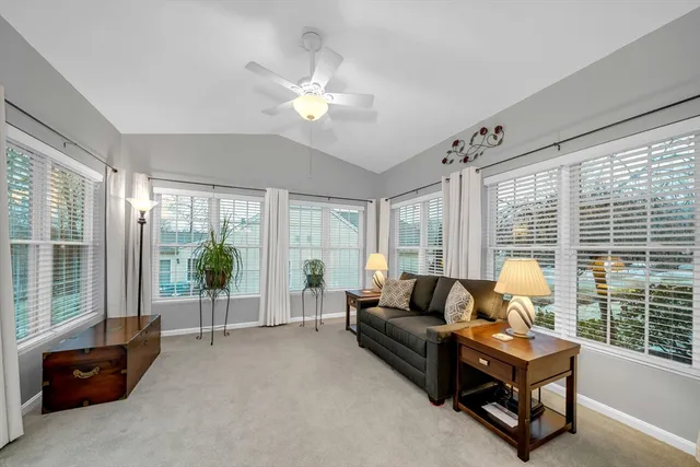 a living room with furniture and large windows
