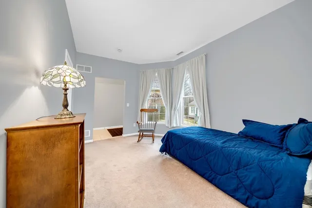 a bedroom with a bed chandelier and a window