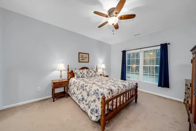 a bedroom with a bed chandelier and a window
