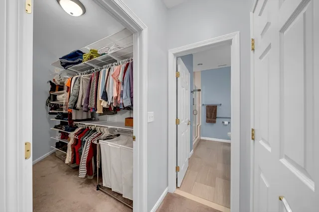 a view of walk in closet with clothes and shoes
