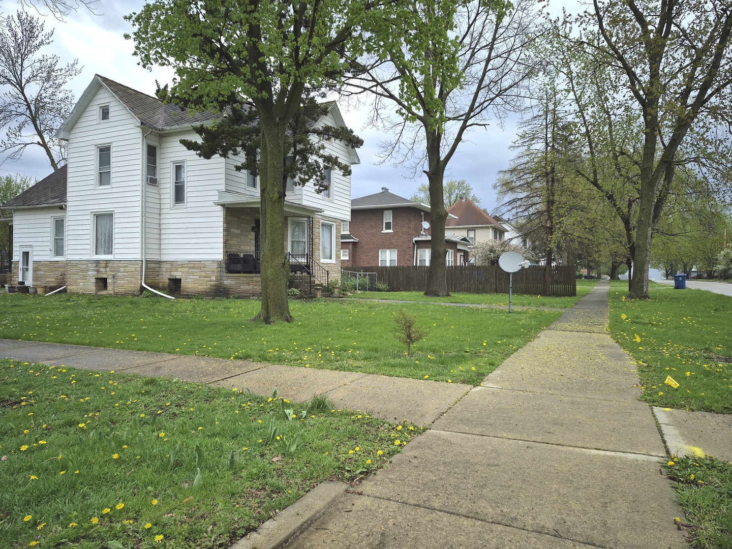 305 East Jackson Street Cullom, IL 60929 - Photo 23 of 23 a view of a white house with a big yard plants and large trees