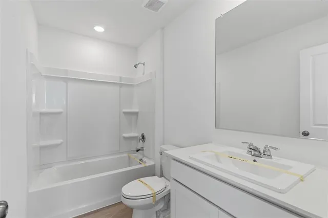 a bathroom with a granite countertop sink toilet mirror vanity and bathtub