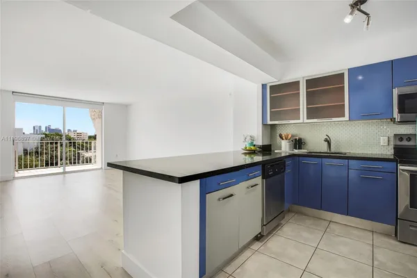 a kitchen with granite countertop a stove and cabinets