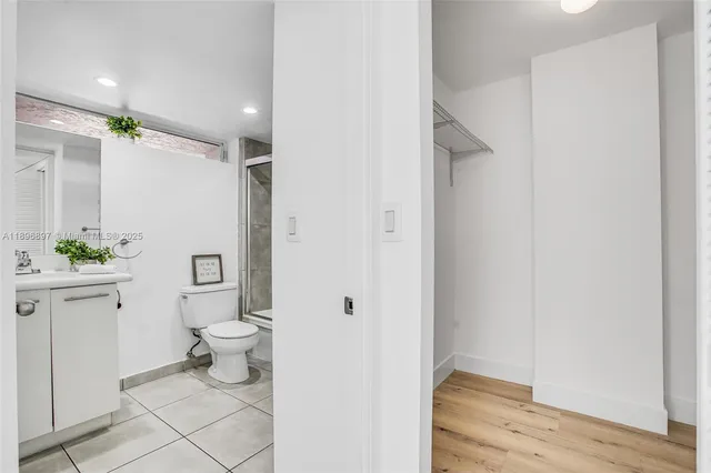 a bathroom with a toilet a sink a shower and a mirror