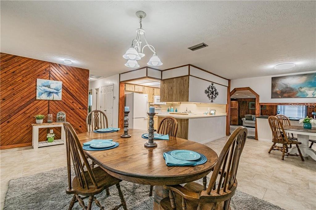 1453 Creek Road Wesley Chapel, FL 33543 - Photo 13 of 26 a view of a dining room with furniture wooden floor and chandelier