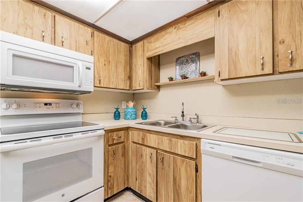 1453 Creek Road Wesley Chapel, FL 33543 - Photo 14 of 26 a kitchen with stainless steel appliances granite countertop a sink a stove and cabinets