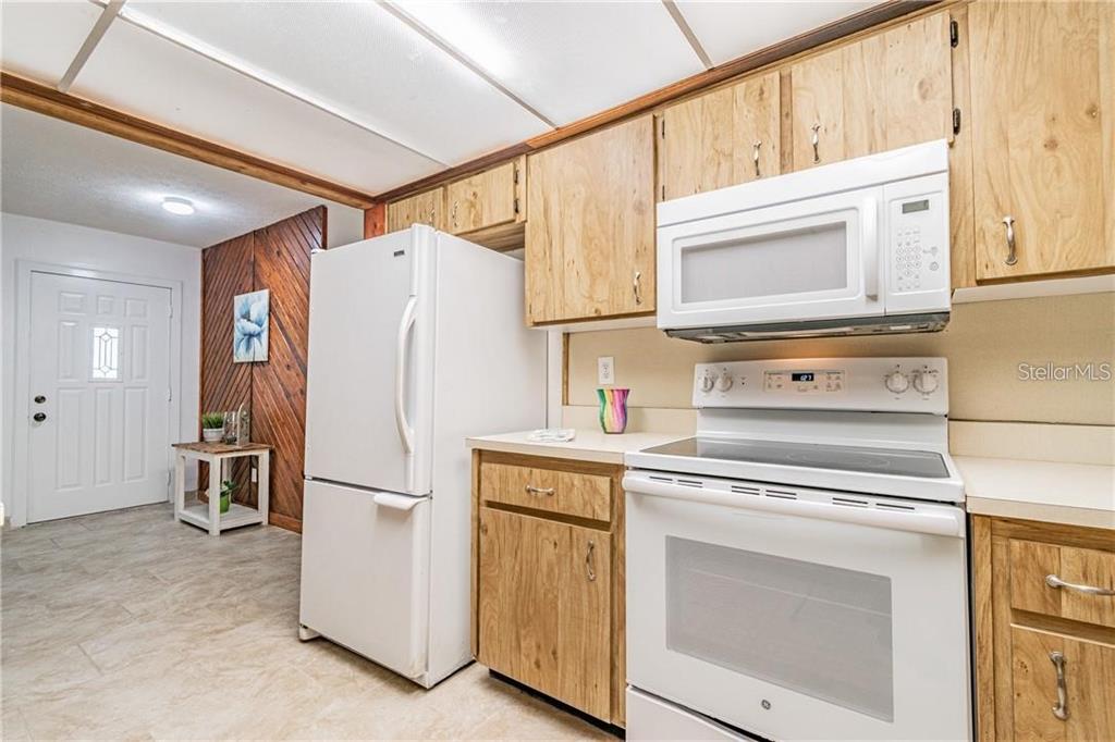 1453 Creek Road Wesley Chapel, FL 33543 - Photo 15 of 26 a kitchen with stainless steel appliances white cabinets and a refrigerator