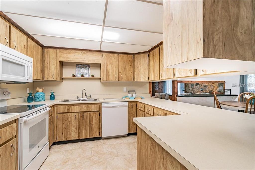 1453 Creek Road Wesley Chapel, FL 33543 - Photo 16 of 26 a kitchen with stainless steel appliances a sink a stove a refrigerator cabinets and a window