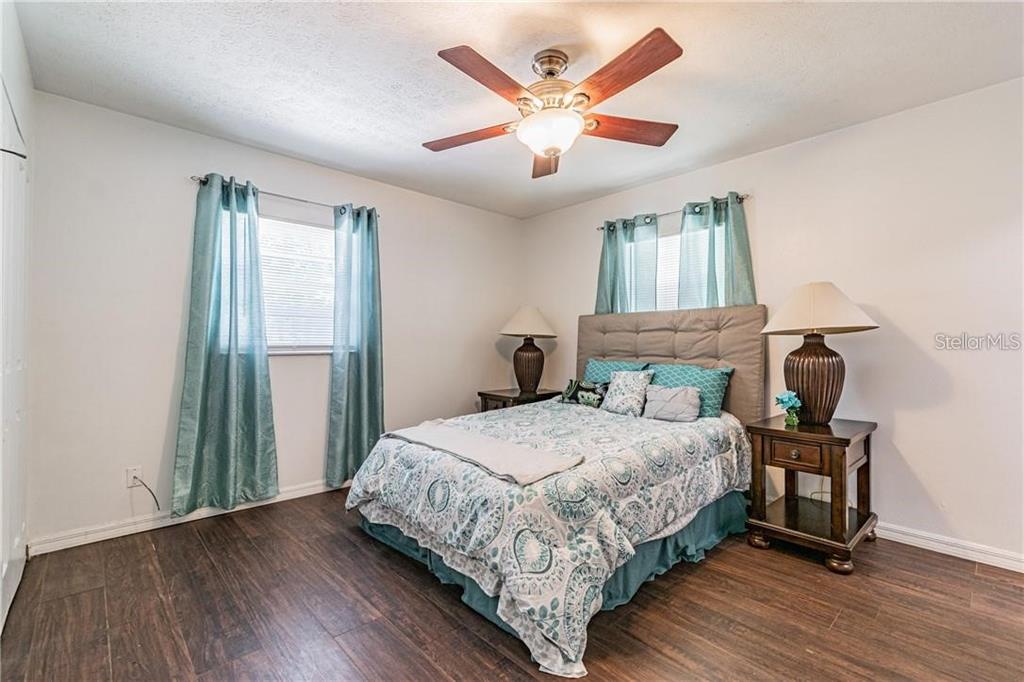 1453 Creek Road Wesley Chapel, FL 33543 - Photo 19 of 26 a bedroom with a bed and a chandelier