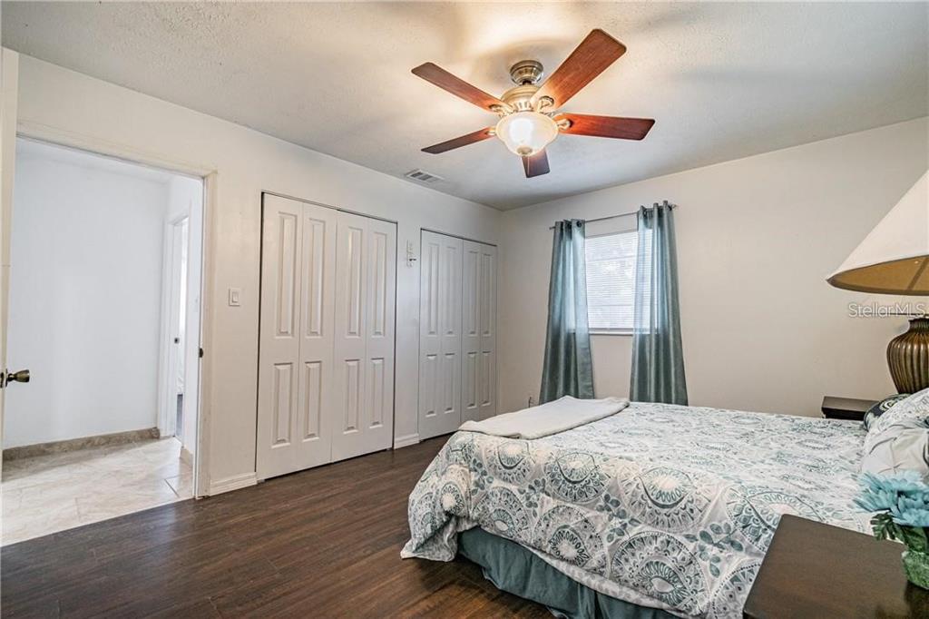 1453 Creek Road Wesley Chapel, FL 33543 - Photo 20 of 26 a bedroom with a large bed and a chandelier