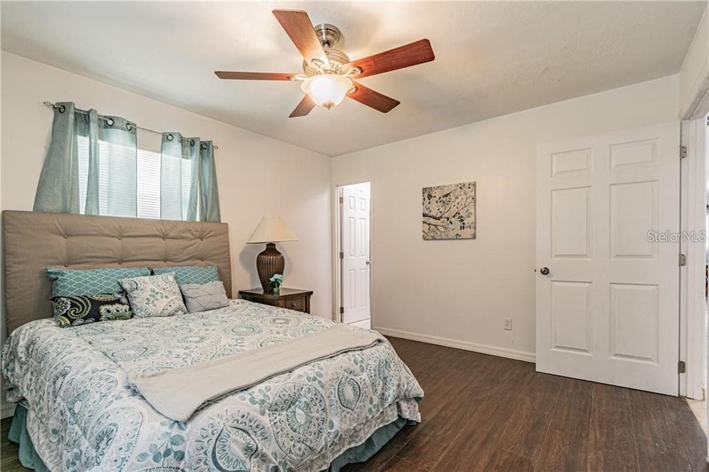 1453 Creek Road Wesley Chapel, FL 33543 - Photo 21 of 26 a bedroom with a large bed and a ceiling fan