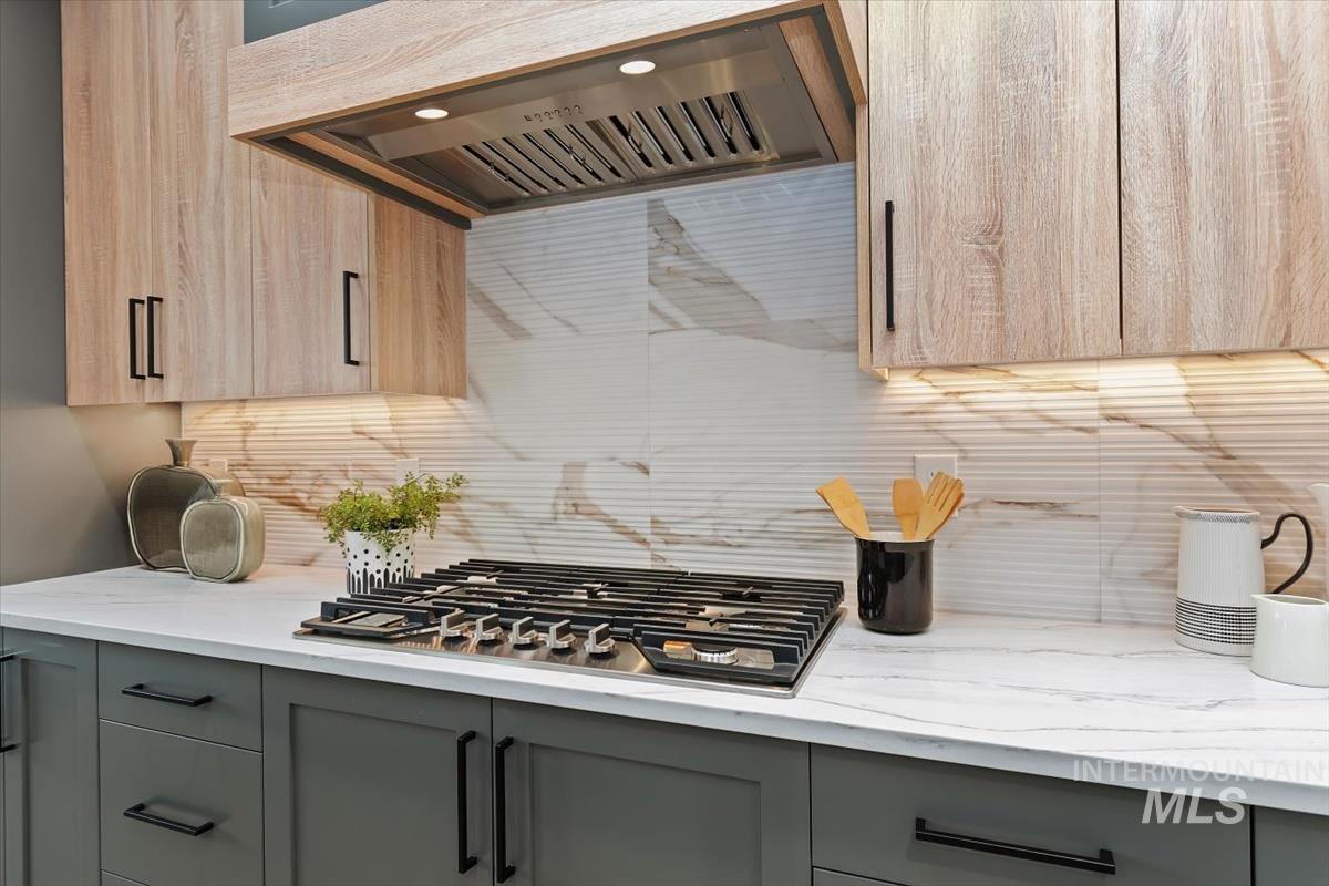 357 West Flour Mill Middleton, ID 83644 - Photo 12 of 49 Kitchen with range hood, light stone countertops, stainless steel gas stovetop, and decorative backsplash