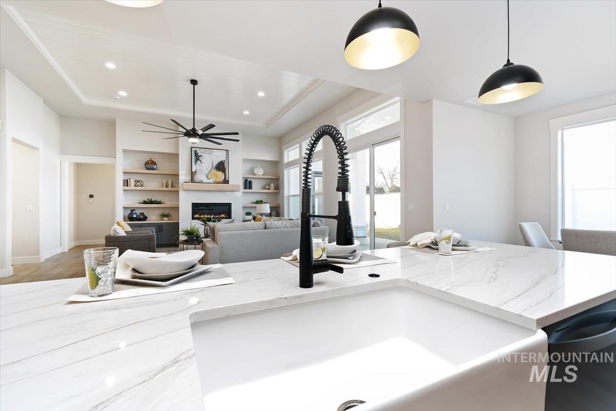 357 West Flour Mill Middleton, ID 83644 - Photo 14 of 49 Kitchen with a raised ceiling, light stone counters, built in shelves, a glass covered fireplace, and dishwasher