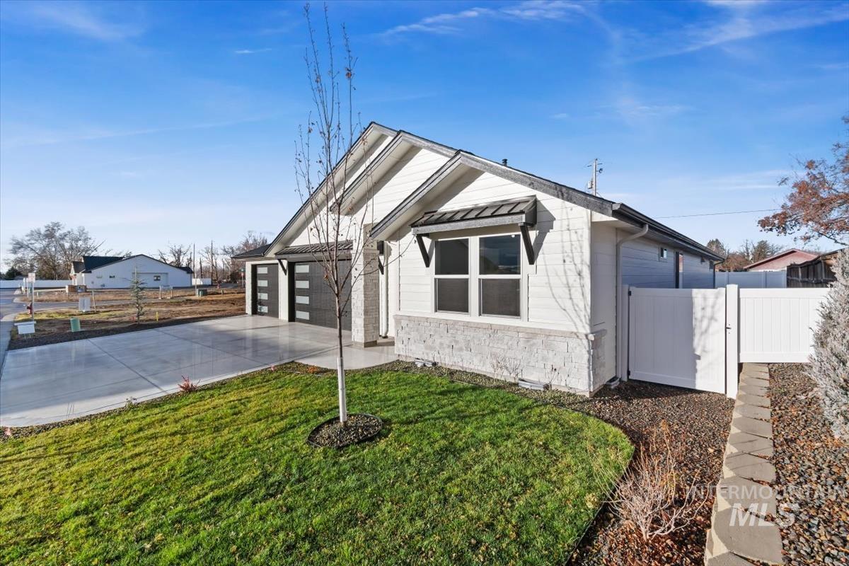 357 West Flour Mill Middleton, ID 83644 - Photo 41 of 49 View of front facade featuring stone siding, a gate, concrete driveway, a standing seam roof, and a garage