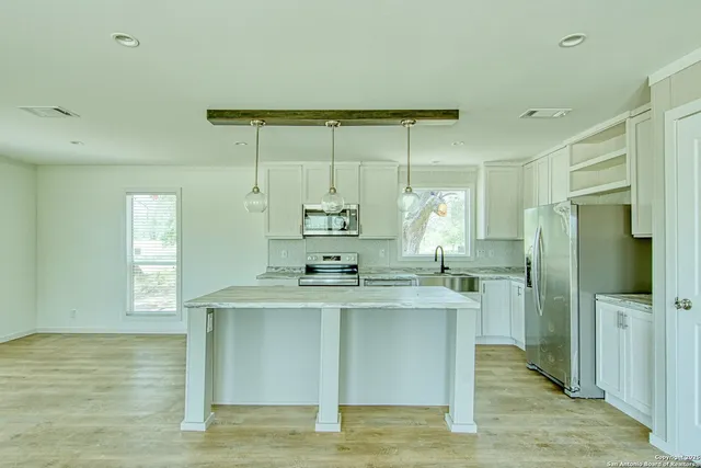 a kitchen with stainless steel appliances a sink and a refrigerator