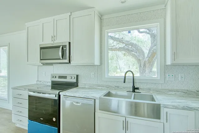 a kitchen with appliances a sink and a cabinets