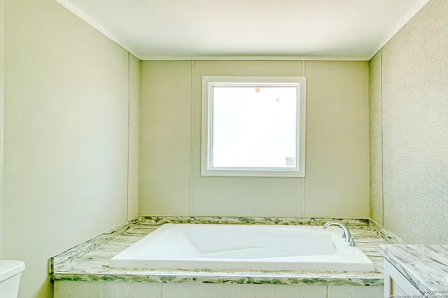 a bathroom with a granite countertop sink and a bathtub