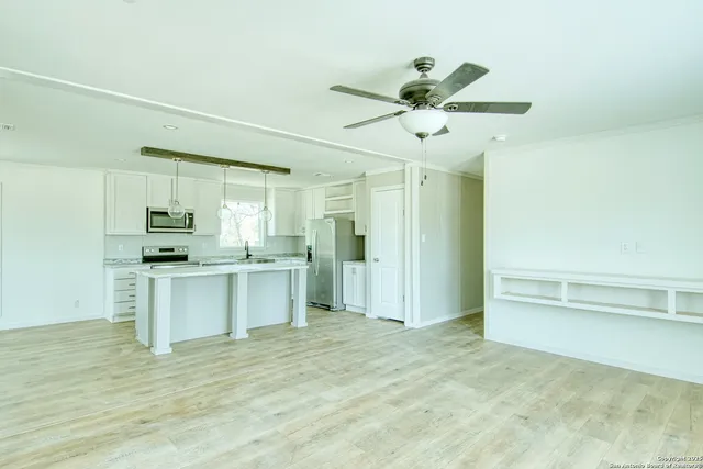 a kitchen with a refrigerator and white cabinets