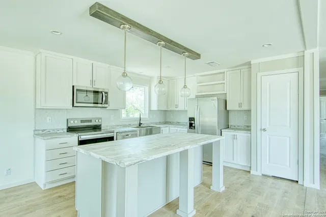 a kitchen with a sink appliances and cabinets