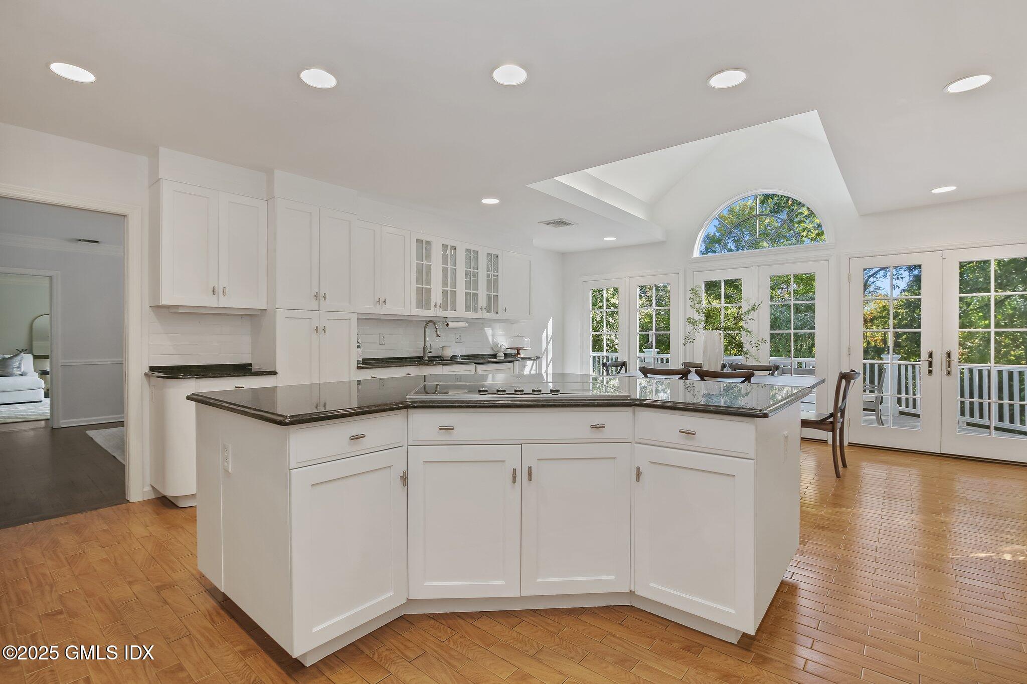 8 Tinker Lane Greenwich, CT 06830 - Photo 11 of 41 a kitchen with granite countertop white cabinets and wooden floor