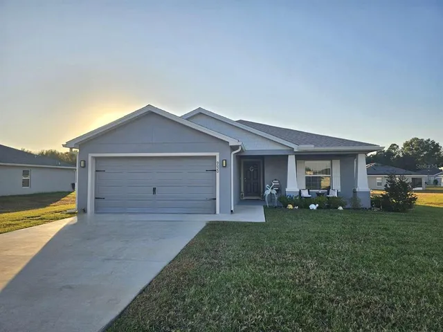a view of a house with a yard and garage