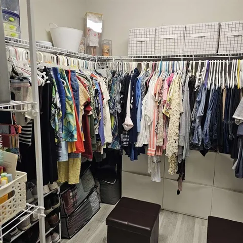 a view of walk in closet with clothes