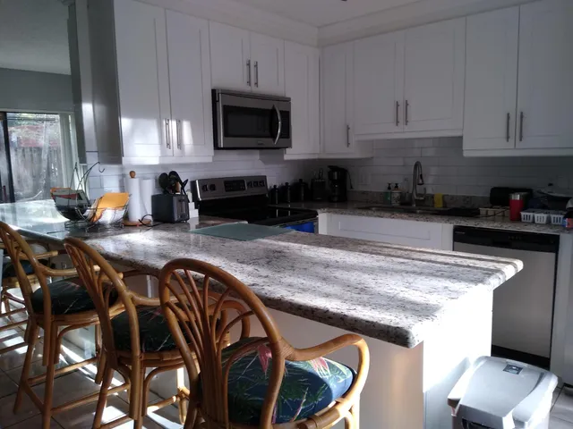 a kitchen with stainless steel appliances granite countertop a stove a sink and a microwave