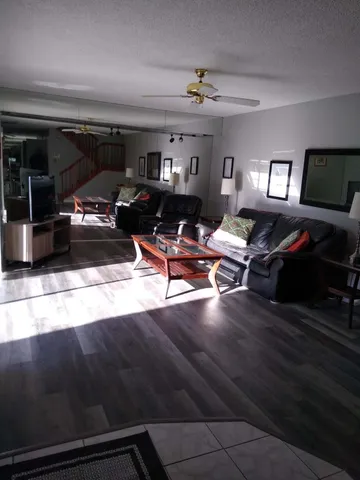 a living room with lots of furniture and view of kitchen