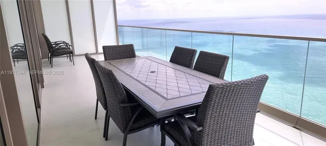 a dining room with furniture and a floor to ceiling window