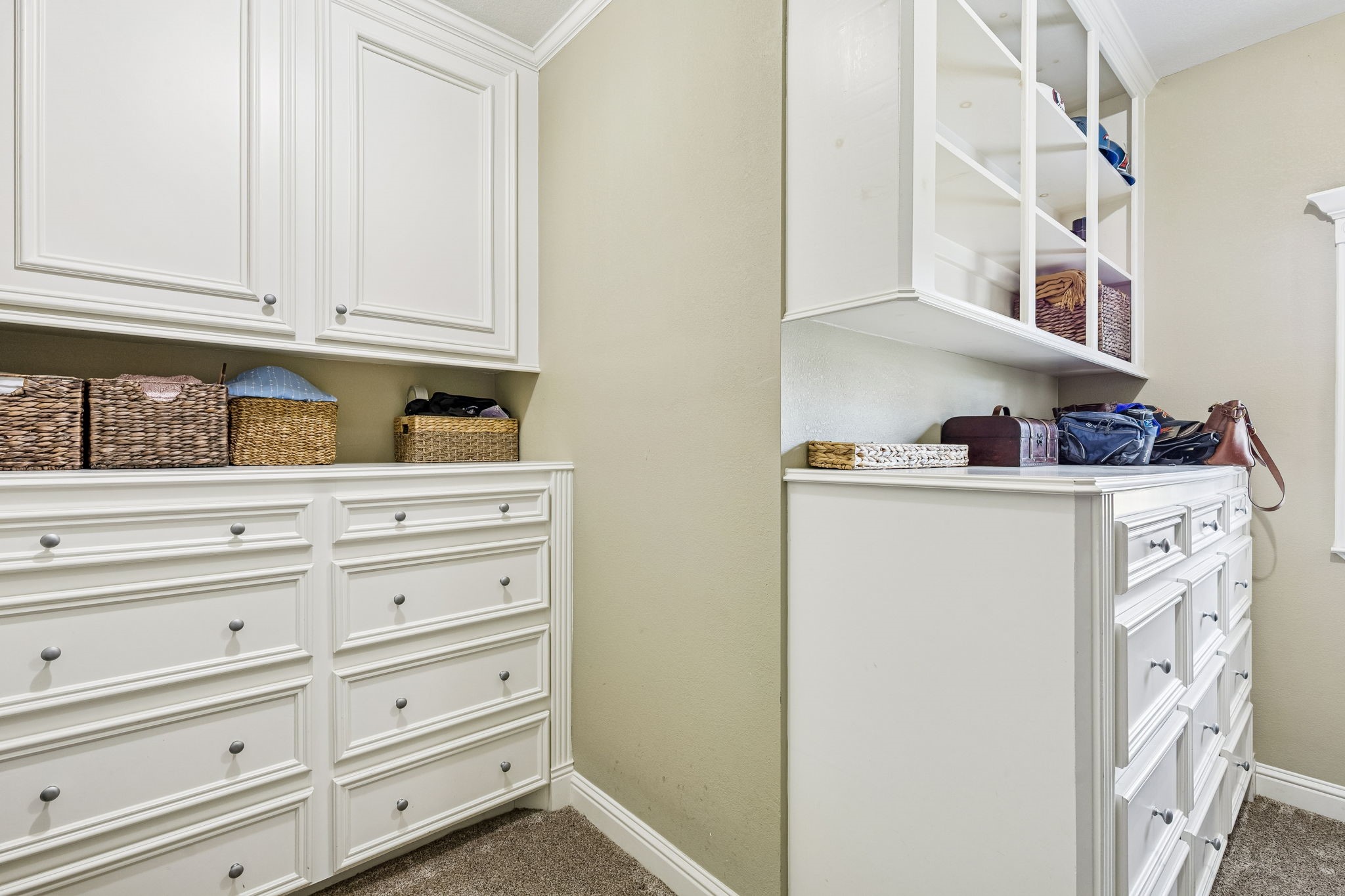 2217 Bernie Avenue Rosenberg, TX 77471 - Photo 13 of 25 Organization is effortless in the oversized primary walk-in closet, featuring extensive white built-in dresser drawers and shelving.