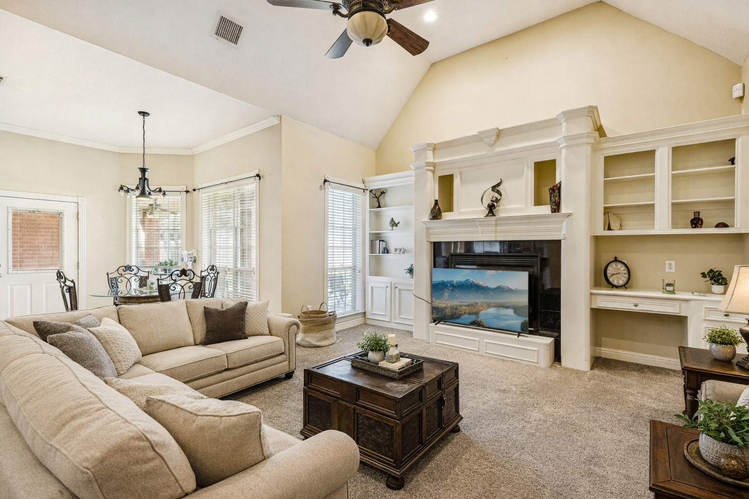 2217 Bernie Avenue Rosenberg, TX 77471 - Photo 4 of 25 The living area features a high ceiling and custom built-in shelving centered around a cozy gas log fireplace. This space has been virtually staged to showcase its potential.