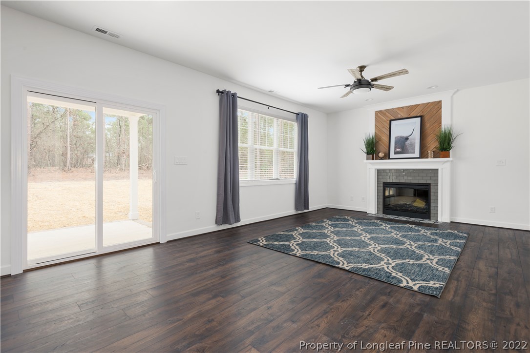 15581 Raccoon Run Road Wagram, NC 28396 - Photo 16 of 30 a view of an empty room with wooden floor fireplace and a window