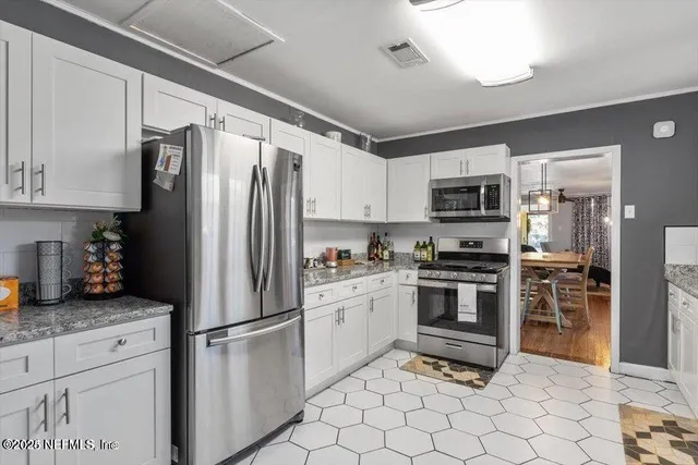 a kitchen with stainless steel appliances granite countertop a refrigerator stove microwave and sink