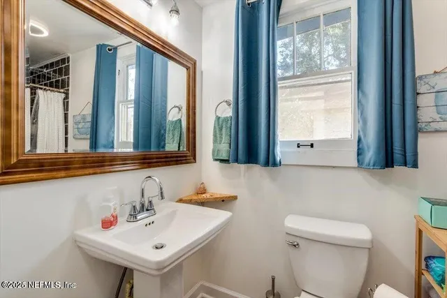 a bathroom with a sink a toilet and a mirror