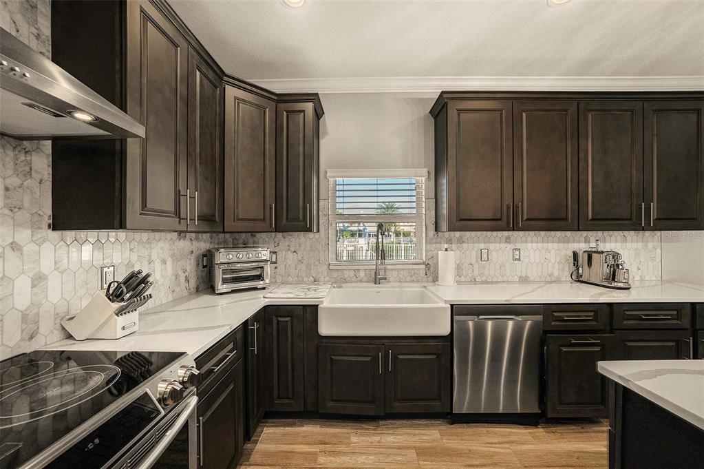 6412 Key Island Boulevard Apollo Beach, FL 33572 - Photo 11 of 42 a kitchen with stainless steel appliances wooden cabinets and a stove top oven