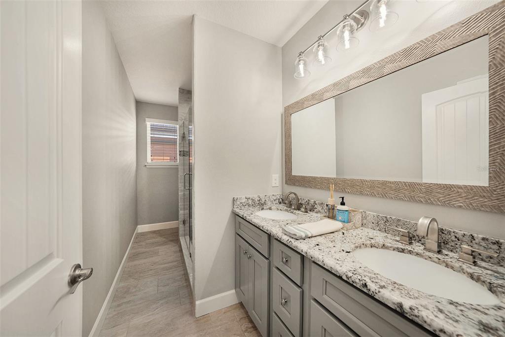 6412 Key Island Boulevard Apollo Beach, FL 33572 - Photo 23 of 42 a bathroom with a granite countertop sink and a mirror