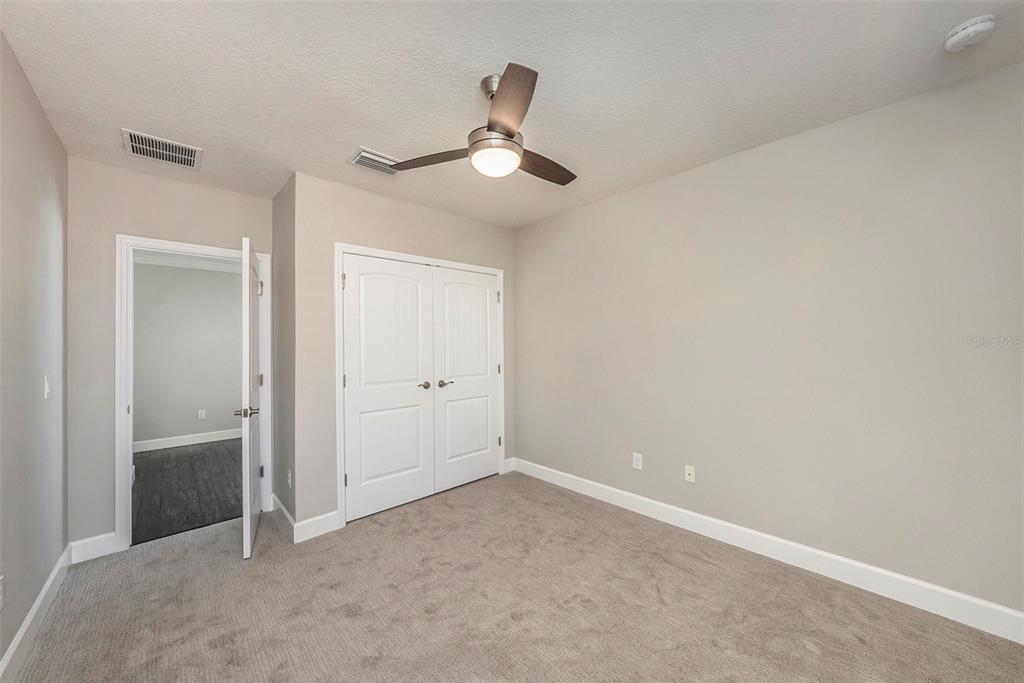 6412 Key Island Boulevard Apollo Beach, FL 33572 - Photo 30 of 42 an empty room with closet and a chandelier fan