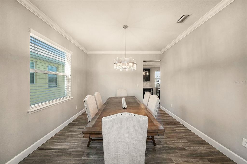 6412 Key Island Boulevard Apollo Beach, FL 33572 - Photo 7 of 42 a dining room with furniture a chandelier and wooden floor