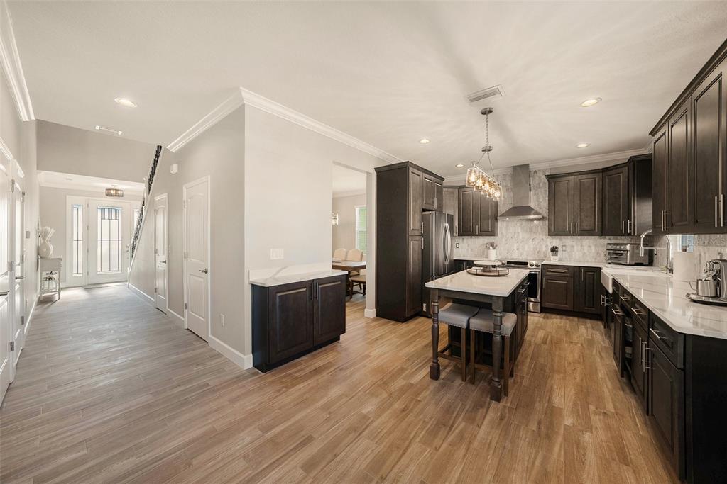 6412 Key Island Boulevard Apollo Beach, FL 33572 - Photo 9 of 42 a kitchen with stainless steel appliances a refrigerator a sink dishwasher a stove and a oven with wooden floor