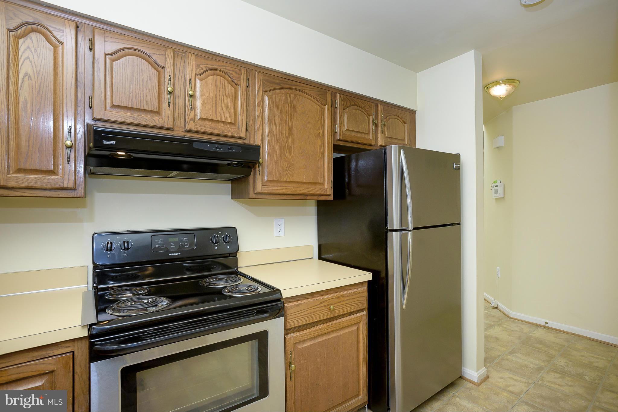 14243 Greenview Drive Laurel, MD 20708 - Photo 10 of 26 a kitchen with stainless steel appliances granite countertop a refrigerator stove and cabinets