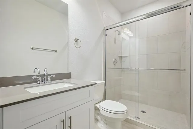 a bathroom with a sink shower and a toilet