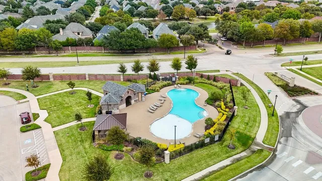 an aerial view of a swimming pool with a yard and outdoor seating