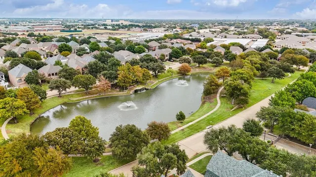 an aerial view of a residential houses with outdoor space and trees all around
