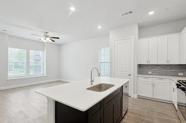 a kitchen with a sink appliances and cabinets