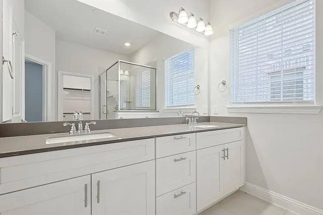 a bathroom with double sink and a mirror
