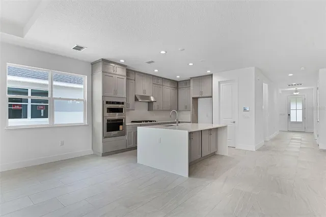 a large kitchen with a large counter top appliances and cabinets