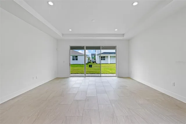 a view of an empty room with a fireplace and a ceiling fan