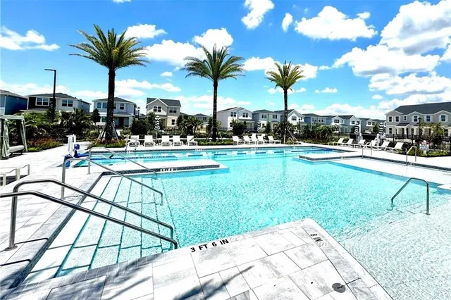 a living room with furniture large windows wooden floor and floor to ceiling windows